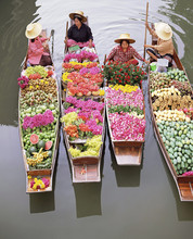 A Group Of Four Women Market Traders In Boats Laden With Fruit And Flowers, Damnoen Saduak Floating Market, Bangkok