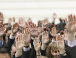 Closeup of business crowd raising hands