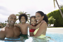 Portrait Of Happy African American Parents With Children In Swimming Pool