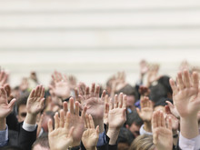 Closeup Of Business Crowd Raising Hands