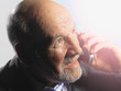 © MDBPIXS - Closeup of a middle aged businessman looking into bright light while talking on mobile phone