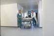 © MDBPIXS - Medical workers moving patient on gurney through hospital corridor