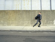 © MDBPIXS - Full length of businessman in suit running on pavement looking back