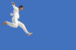 © MDBPIXS - Full length of young businessman jumping against blue sky