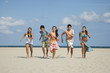 © MDBPIXS - Full length of happy teenage friends running on sandy beach