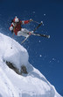 Low angle view of a skier in midair above snow on ski slope