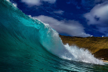 Wall Mural - bright clear blue ocean wave near coast barrel for surfing lessons