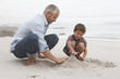 © MDBPIXS - Father and son preparing sand castle together on beach