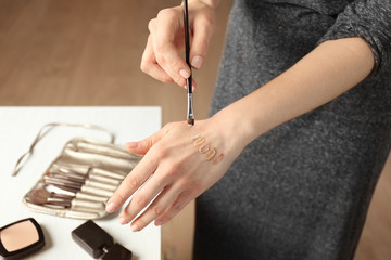 Poster - Female visagiste applying cosmetics onto hand