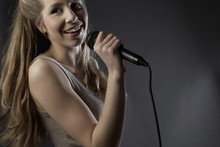Closeup Of Beautiful Teenage Girl Singing Into Microphone In Studio