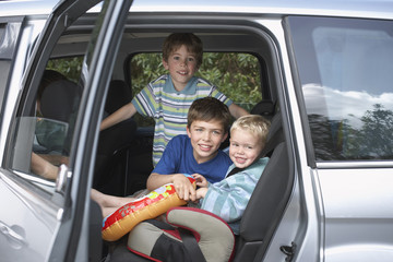 Portrait of three smiling boys in the car