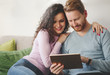 © NDABCREATIVITY - Happy couple surfing on tablet at home