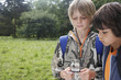Two young boys with backpacks using compass
