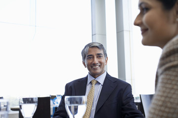 Wall Mural - Happy middle aged businessman with female colleague in restaurant