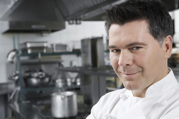 Wall Mural - Closeup portrait of a smiling male chef in the kitchen