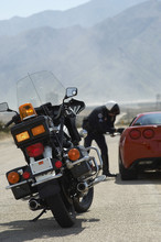 Motorcycle On Road With Police Man By Car In The Background