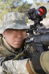 Wall Mural - Closeup of US army solider aiming to shoot with machine gun