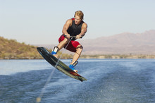 Young Man Wakeboarding On Lake