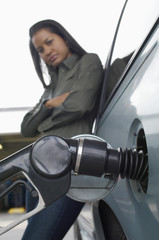 African American woman refueling car at gas station