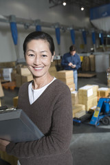 Wall Mural - Portrait of a smiling Asian woman in distribution warehouse