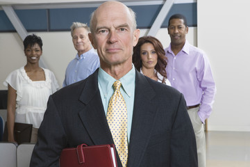 Wall Mural - Portrait of a serious businessman with multiethnic executives behind