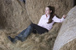 Full length of a young thoughtful woman relaxing in the barn