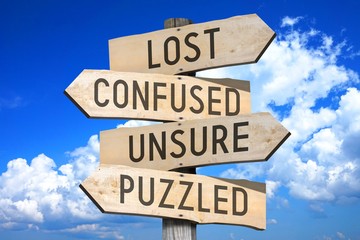 Wall Mural - Wooden signpost with four arrows - confused, unsure, puzzled, problem - great for topics like being lost/ confused etc.