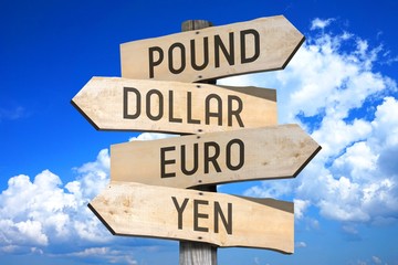 Wooden signpost with four arrows - pound, dollar, euro, yen - great for topics like currencies etc.