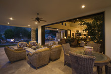Wicker Furniture In Lit Spacious Home With Porch View At Night