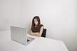 © MDBPIXS - Angry young businesswoman with arms crossed looking at laptop in office