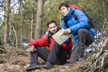 Backpackers with map in forest