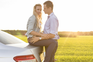 Wall Mural - Side view of romantic young couple by car at countryside