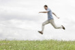 © MDBPIXS - Blurred motion of young man jumping in park against sky