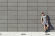 © MDBPIXS - Full length of tired sporty man leaning on tiled wall