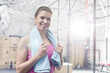 © MDBPIXS - Portrait of happy woman holding towel around neck in crossfit gym