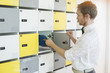 © MDBPIXS - Side view of creative businessman putting files in locker at office