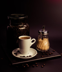 Wall Mural - Cappuccino. Concept. Glass jar with coffee beans and brown sugar cane on a dark background. Retro. Vintage.