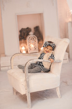 Cute Baby Girl Under 1 Year Old Wearing Stylish Clothes Sitting In Vintage Chair In Room. Winter Season.