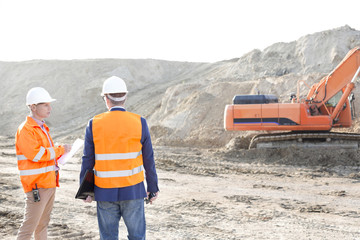 Wall Mural - Supervisors standing at construction site against clear sky