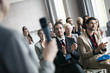 © MDBPIXS - Business people applauding for public speaker during seminar