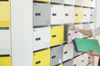 © MDBPIXS - Cropped image of businessman putting files in locker at creative office