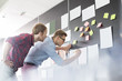 © MDBPIXS - Businessmen analyzing documents on wall in office
