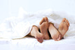 © MDBPIXS - Close-up of the feet of a couple on the bed