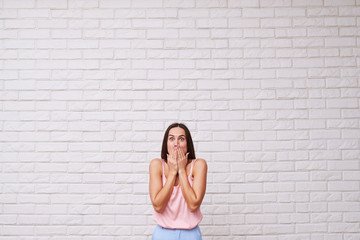 Wall Mural - Mid shot of surprised woman covering mouth with hands and lookin