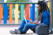 © santypan - Portrait of african man sitting outside with laptop.