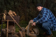 young lumberjack collecting firewood in jute bag