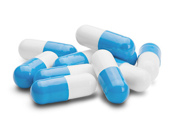 pile of medical pills blue and white on a isolated white backgro