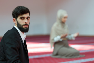 Wall Mural - Muslim man and woman praying in mosque