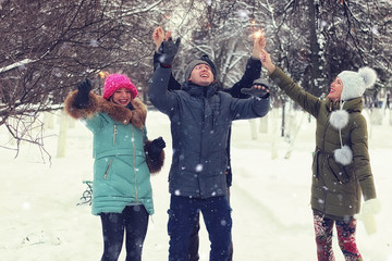 winter group of young people with sparklers