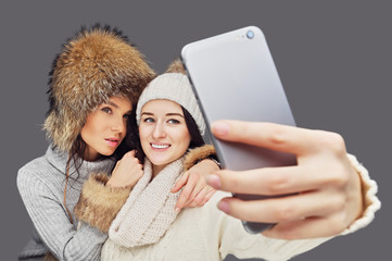 Wall Mural - Two women doing selfie with smartphone.